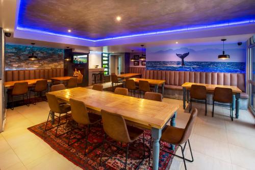 a restaurant with a large wooden table and chairs at Bishops Lodge in Gqeberha