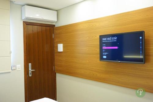 a flat screen tv on a wall in a room at Hotel Park in Valparaíso de Goiás