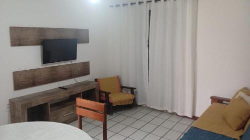 Una sala de estar con televisión, sofá y sillas. en Residencial Três Irmas, en Florianópolis
