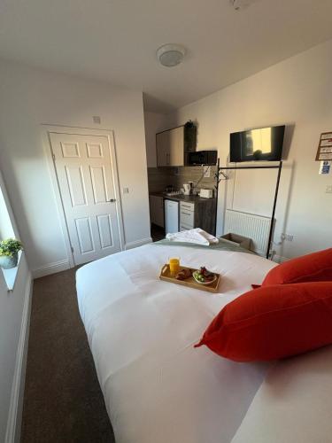 a large white bed with a tray of food on it at Central Peterborough Studio 6 in Peterborough