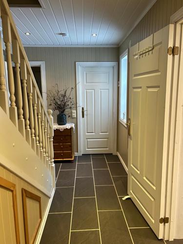 a hallway with a white door and a tiled floor at Stille og fredelig ved fjord og fjell in Valsøybotn