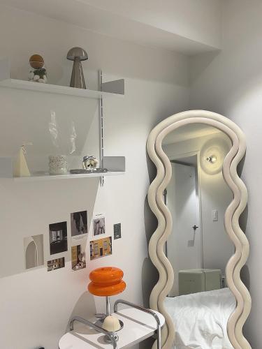 a bedroom with a large circular mirror and a stool at Busan Manoah Stay in Busan