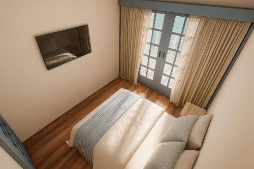 a bedroom with a couch and a tv and a window at Vila Dorathea in Blumenau