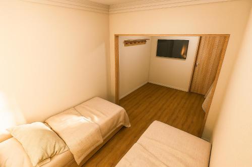 a small room with a couch and a television at Vila Dorathea in Blumenau
