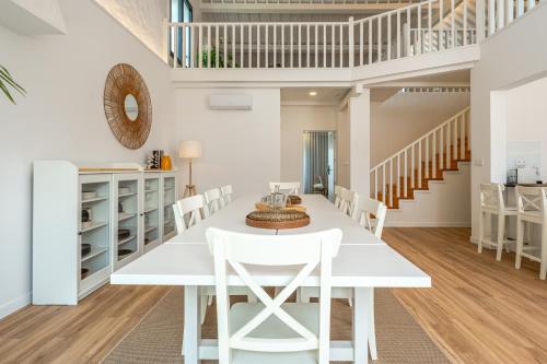 a white dining room with a white table and chairs at Ápice - by Azores Green Villas in São Vicente Ferreira