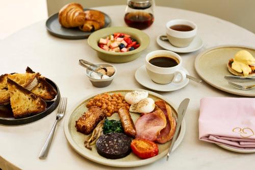 a table with plates of breakfast food and cups of coffee at House of George W Davies in Broadway