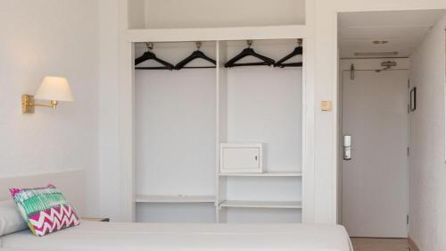 a bedroom with a white bed and a closet at htop Olympic #htopEnjoy in Calella