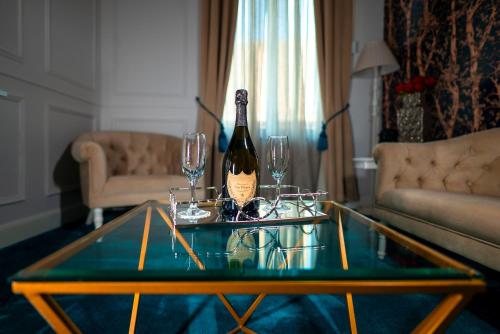 a bottle of wine on a glass table in a living room at Hotel Splendid 1900 in Craiova