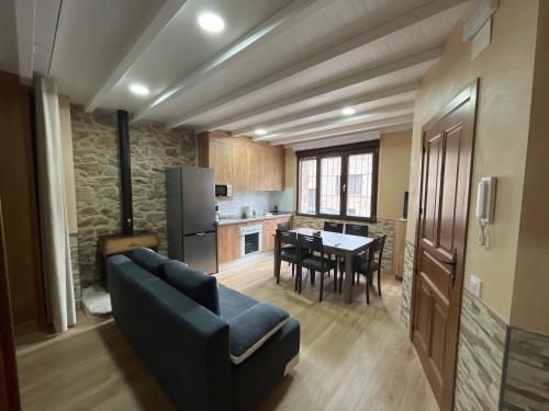 a living room with a couch and a kitchen with a table at Mar de Nubes Piornal 1 in Piornal