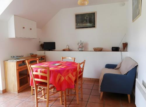 a room with a table and chairs and a kitchen at Gîte À L'orée De Brocéliande 4 pers in La Saudrais