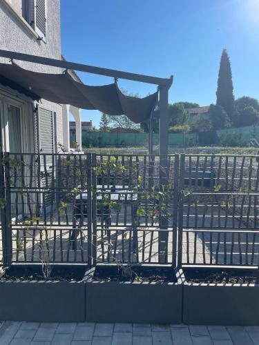 a iron fence with a canopy and tables and chairs at Blueyes House Tuscany in Montespertoli