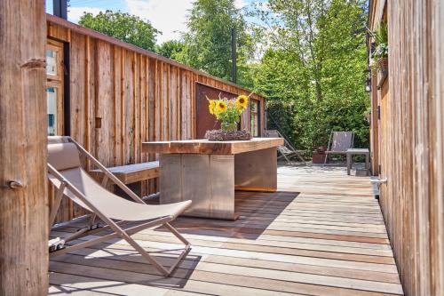 a wooden deck with a table with a vase of flowers at City Suites Murnau in Murnau am Staffelsee