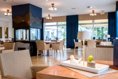 a dining room with a table and chairs and a restaurant at Heidehotel Bad Bevensen in Bad Bevensen