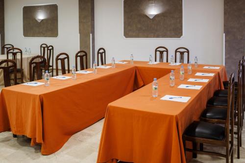 a row of long tables with orange table cloths at Hotel Acosta Vetonia in Almendralejo