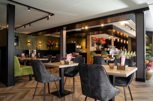 a restaurant with tables and chairs and a bar at Recreatiepark Beekbergen in Beekbergen