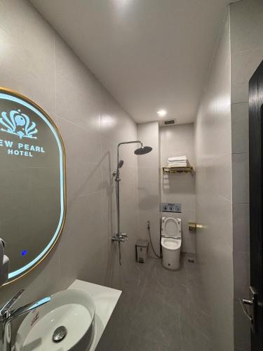 a bathroom with a sink and a mirror and a toilet at New Pearl Hotel HCM in Ho Chi Minh City