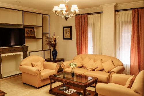 a living room with a couch and two chairs and a table at Hotel Acosta Vetonia in Almendralejo