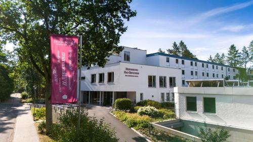 a building with a pink banner in front of it at Heidehotel Bad Bevensen in Bad Bevensen