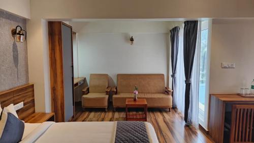 a bedroom with a bed and a couch and a chair at Luxe' Vista by Z Vacations in Kodaikānāl