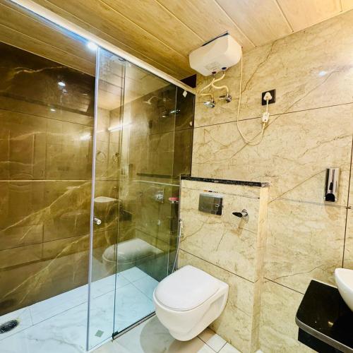 a bathroom with a toilet and a shower at Jasmine Mountain View Retreat - Mall Road Dalhousie in Dalhousie