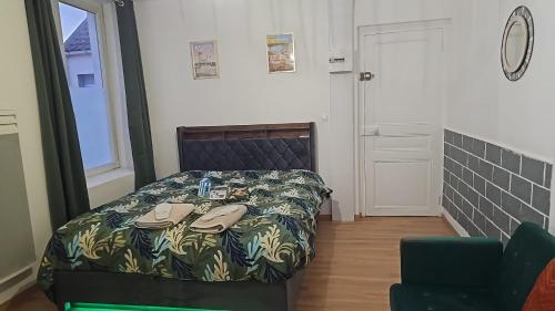 een slaapkamer met een bed met schoenen erop bij Cosy appartement 45m2 vu et accès jardin commun in Outreau
