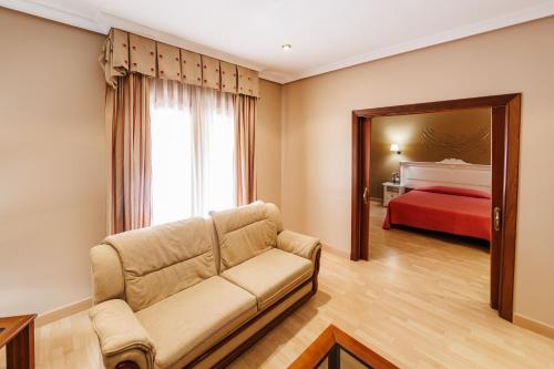 a living room with a couch and a bed at Hotel Acosta Vetonia in Almendralejo