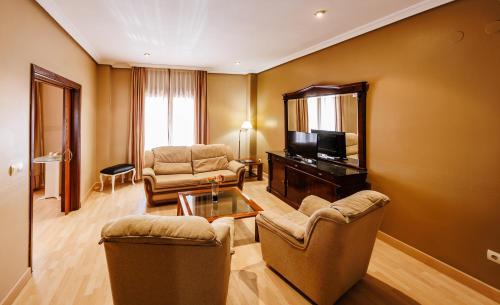 a living room with two chairs and a television at Hotel Acosta Vetonia in Almendralejo