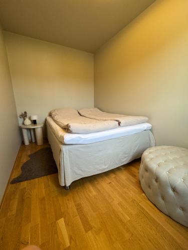 a bedroom with two beds and a ottoman at Moderne Leilighet i Lofoten in Leknes