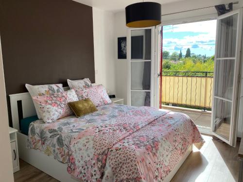 1 dormitorio con 1 cama con sábanas rosas y balcón en Azursalsa, en Roquefort-les-Pins