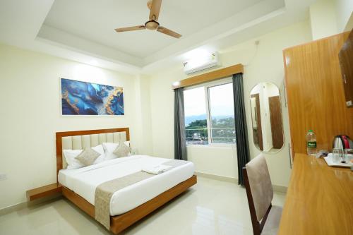 Un dormitorio con una cama y una ventana grande. en Hotel Royal International - Best Boutique Hotel Near Airport & Kamakhya Temple, en Guwahati
