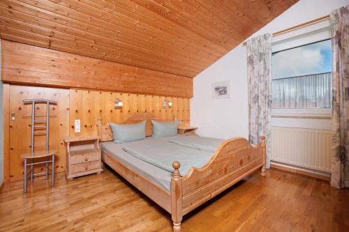 a bedroom with a bed and a wooden ceiling at Ferienwohnung Elfi in Oberreute