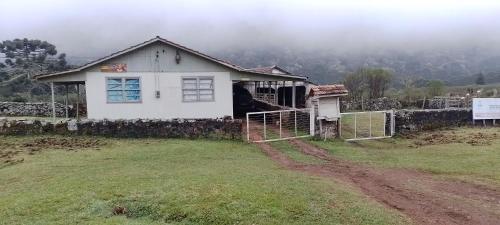 a white house on a hill with a fence at Projeto Puma in Lages
