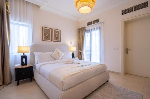 a bedroom with a large white bed with a large window at Coastal Luxury 4BR Apartment with Private Balcony in Abu Dhabi
