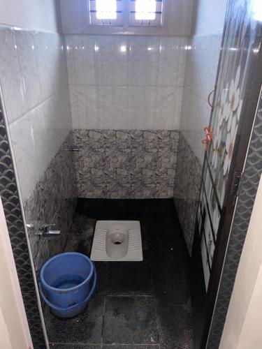 a bathroom with a blue toilet in a stall at Nandini home stay in Sringeri