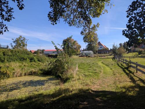 a grassy field with a fence and a field at Ferienwohnungen - barrierefrei - im sanierten Gutshof in Lalendorf