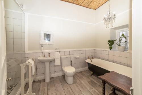 a bathroom with a sink and a toilet and a bath tub at Nantes-vue in Paarl