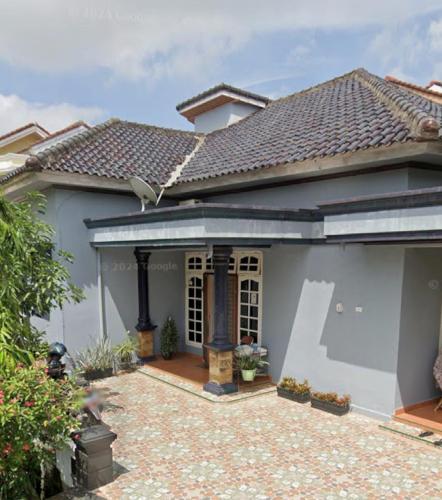 a white house with a tile roof at HOMESTAY DEMANGs in Palembang