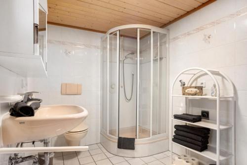 オーバーロイテにあるFerienwohnung Harmonieのシャワーと洗面台を備えた白いバスルーム