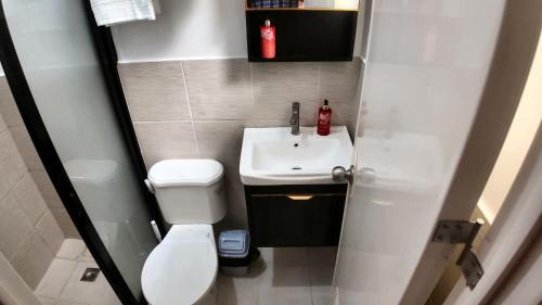 a small bathroom with a toilet and a sink at Rosalia's in Matina in Davao City