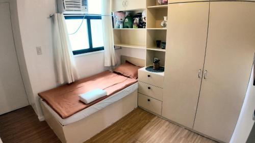 a small bedroom with a bed and a window at Rosalia's in Matina in Davao City