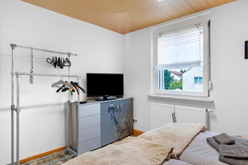 a bedroom with a bed and a tv and a window at Ferienwohnung am Rosenberg in Stockach