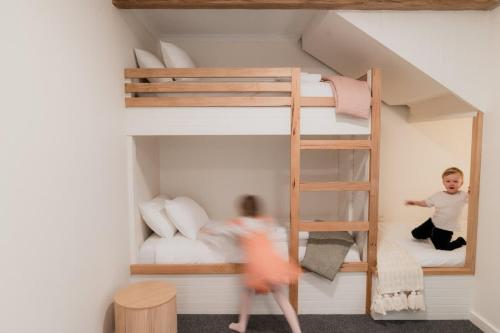 two children playing in a doll house with bunk beds at The Boat House Central Location in Goolwa