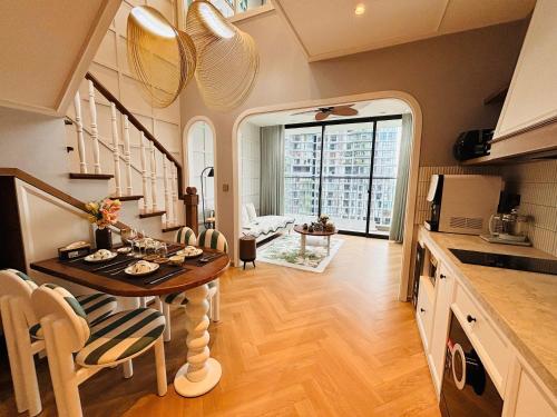 a kitchen with a table and a dining room with a view at Homestay Ecopark Hung Yen by QMP in HÆ°ng YÃªn