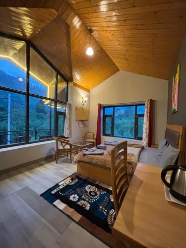 una camera da letto con un letto in una stanza con finestre di HOLIDAYS in HAVEN HOSPITALITY a Manāli