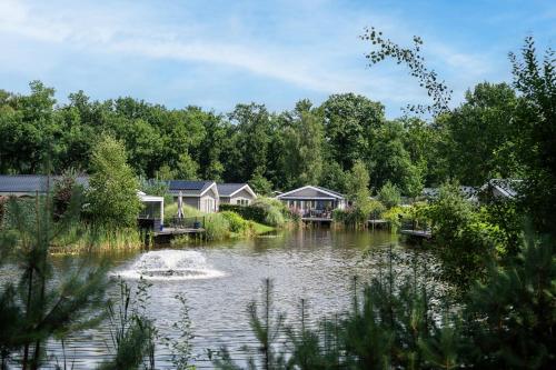 a group of houses on a river with a pond at Recreatiepark Beekbergen in Beekbergen