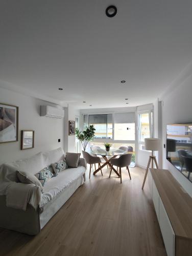 a white living room with a couch and a table at Refugio del Mar Primera linea a estrenar in Algarrobo-Costa