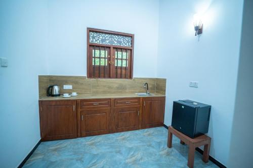 a kitchen with a sink and a window at Araliya Gardens Hotel in Hikkaduwa
