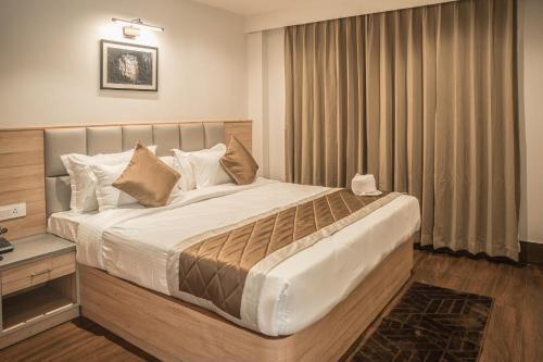 a bedroom with a large bed with white sheets and pillows at Hotel Arjay Valley, Pure Veg Luxury Hotel in Darjeeling