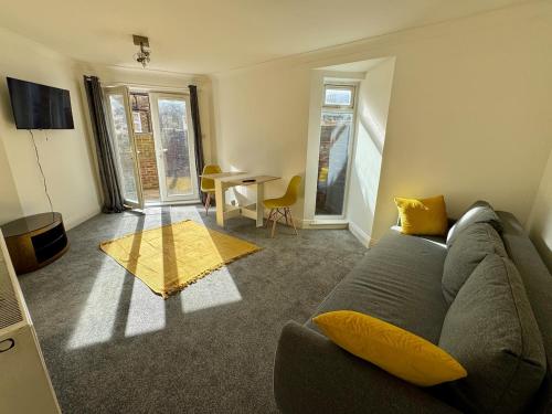 a living room with a couch and a table at Comfortable, London 1 Bed Garden in London