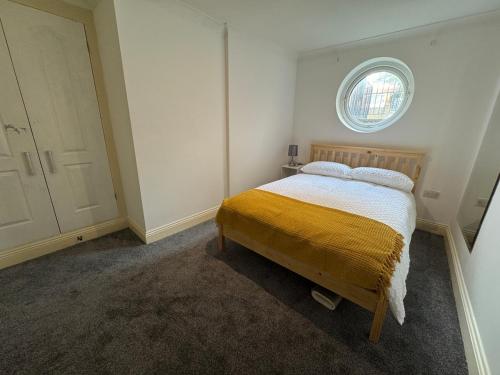 a small bedroom with a bed with a window at Comfortable, London 1 Bed Garden in London